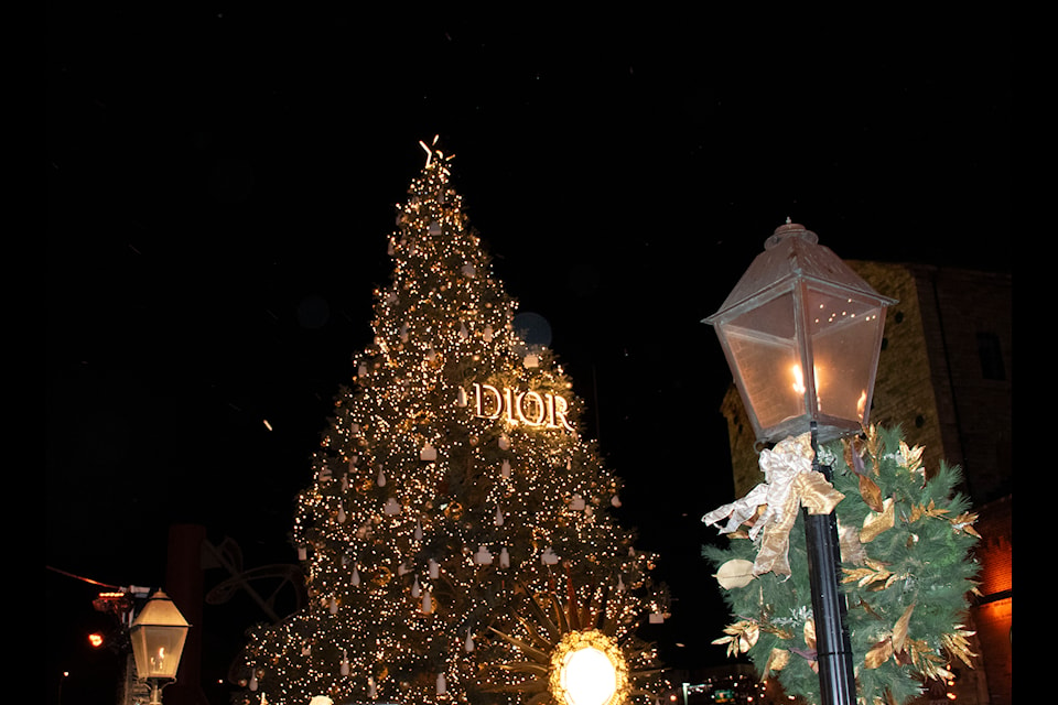 The 55-foot-tall Christmas tree with a Dior sign at the Distillery Winter Village. Thousands of lights adorn the tree.