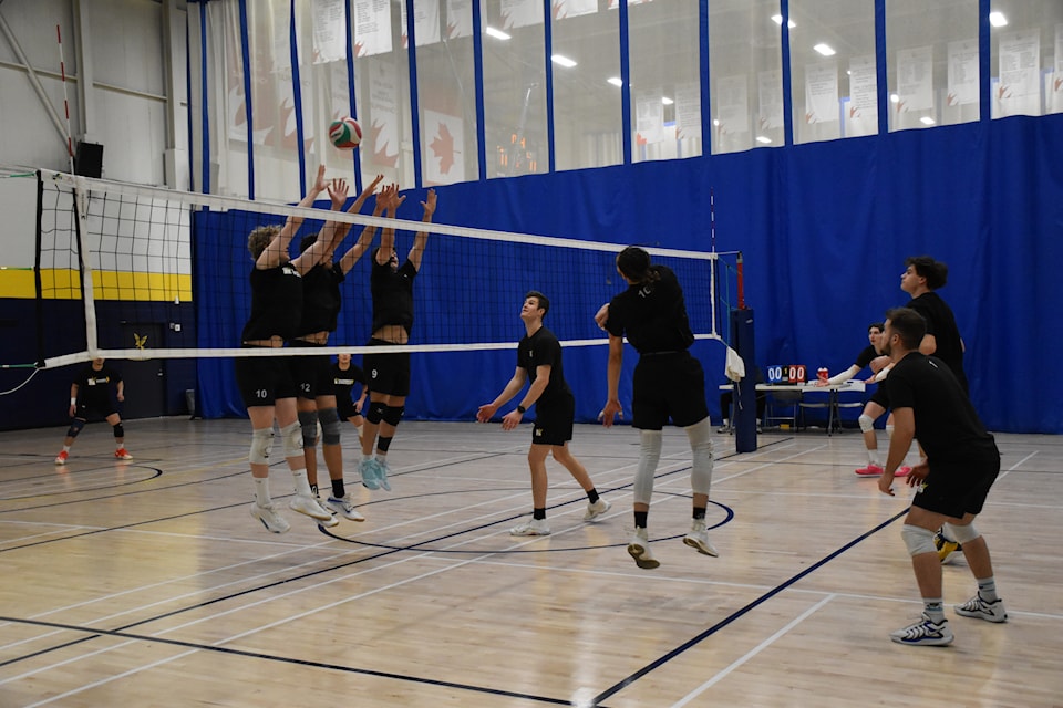 Humber’s outsider Teyven Blackmore on his back after killing the ball while outside hitter Nathan Jager (10), middle Apolo Bras (12) and left sider Brock Mackenzie (9) jump to make a block during the Feb. 11 practice.