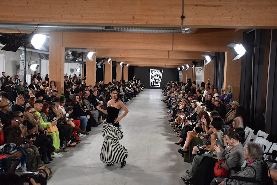 Model walking in black and white striped bubble gown with black tube top bodice