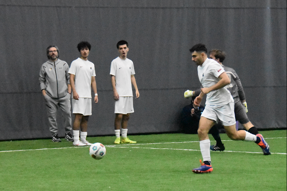 Humber's forward Christian Keshishian after eluding Sheridan's goalkeeper Nicholas Ceglarski to score the sith goal of the match while Humber players Artan Omrani (right), Daniel Prieto (middle) and coach Michael Aquino (left) look astonished.