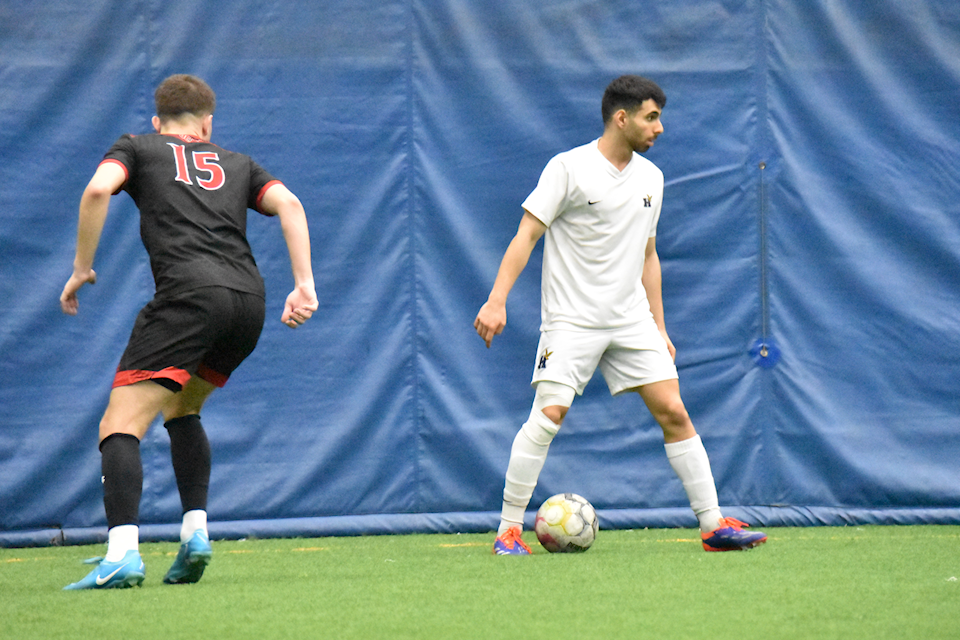 Humber's forward Christian Keshishian (white) with the ball while Fanshawe Falcons' defender Petar Orelj (black) looks at the ball during the OCAA Championship finals on March 6 at the Ontario Soccer Centre in Vaughan, Ont.