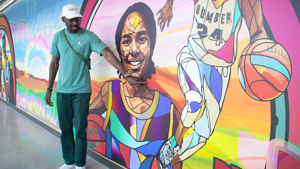 artist-phillip-saunders-points-to-his-mural