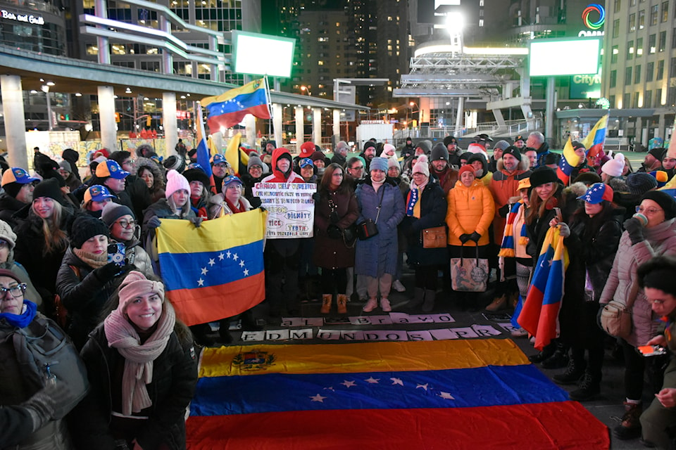 Venezuelans standing around their national flag at a demonstration in downtown Toronto's Dundas Square on Jan. 9.