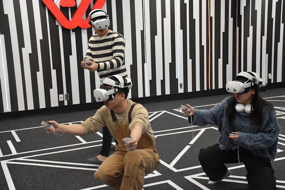 Phebe Chung and her friends, wearing their Meta Quest 3 headsets, are embracing the VR game as a team at Another World VR Arena Mississauga.